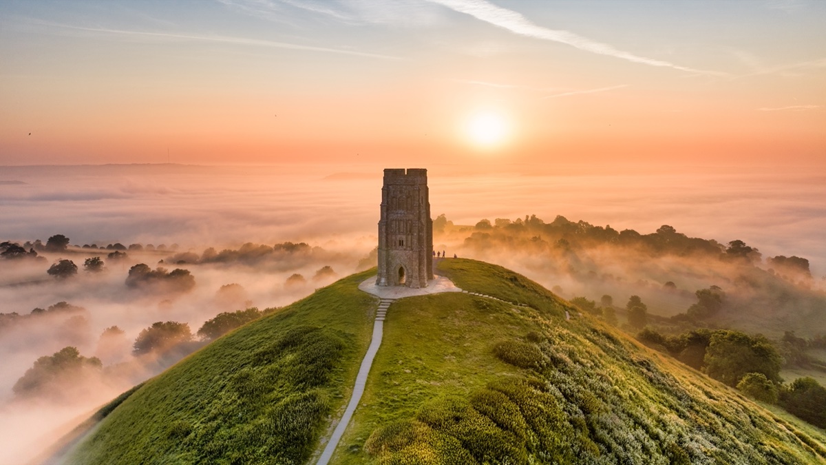 Glastonbury Tor rising above misty Somerset countryside at sunrise