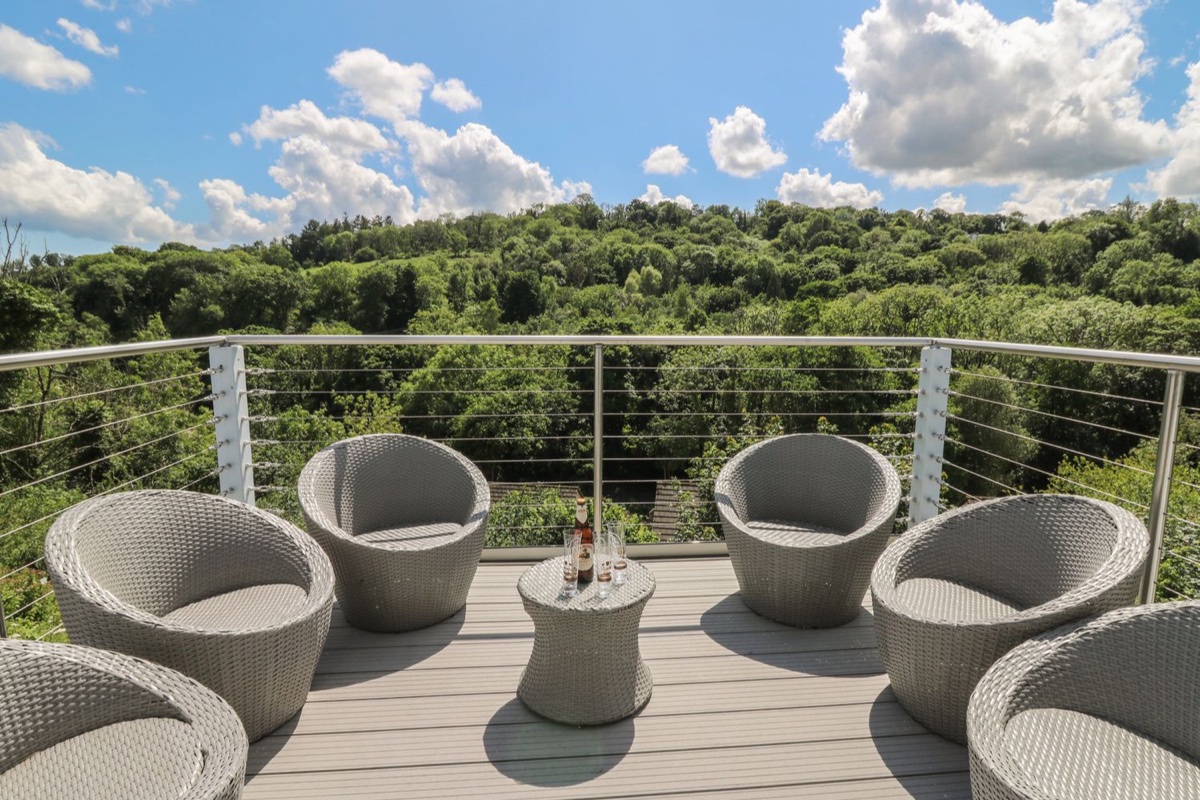 Balcony seating overlooking wooded countryside at 1 Bryn Beudy