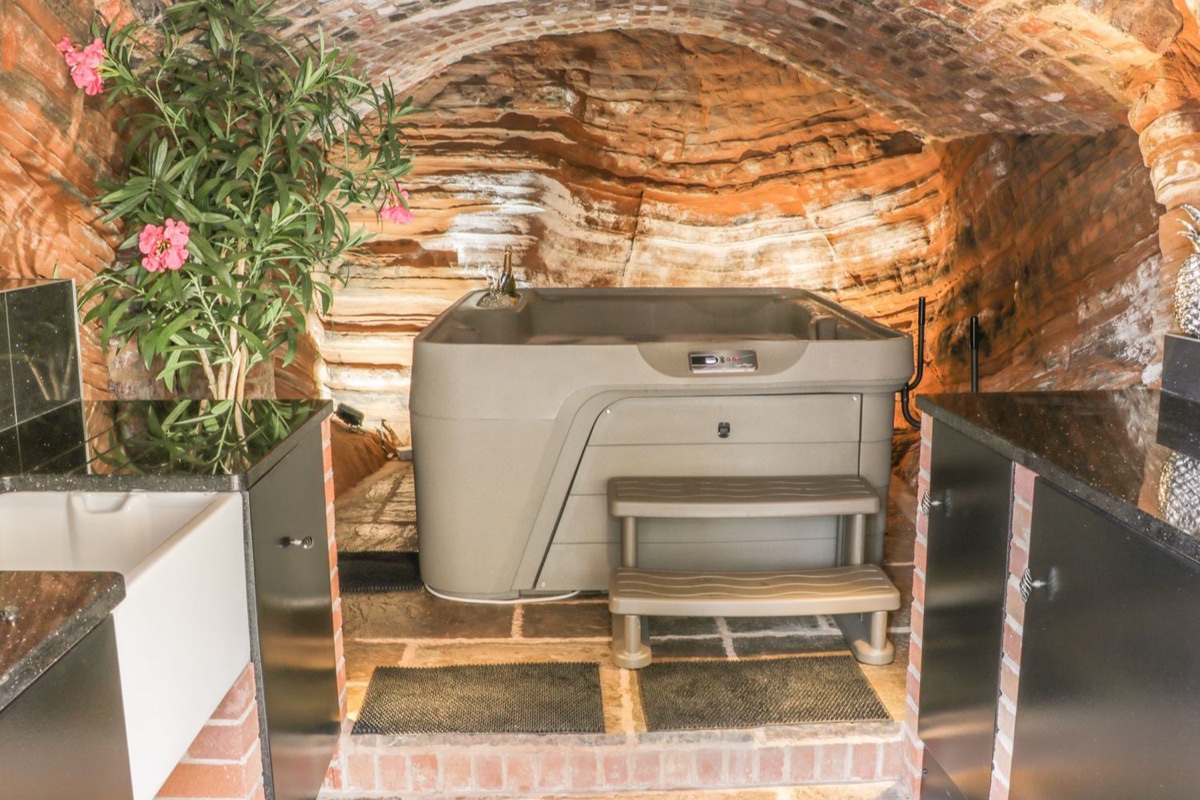 31 Riverside hot tub tucked under a brick and sandstone arch