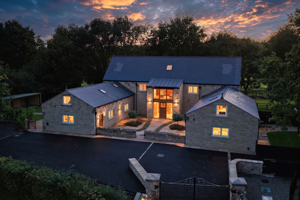 Alston House stone exterior lit at dusk with driveway and garden