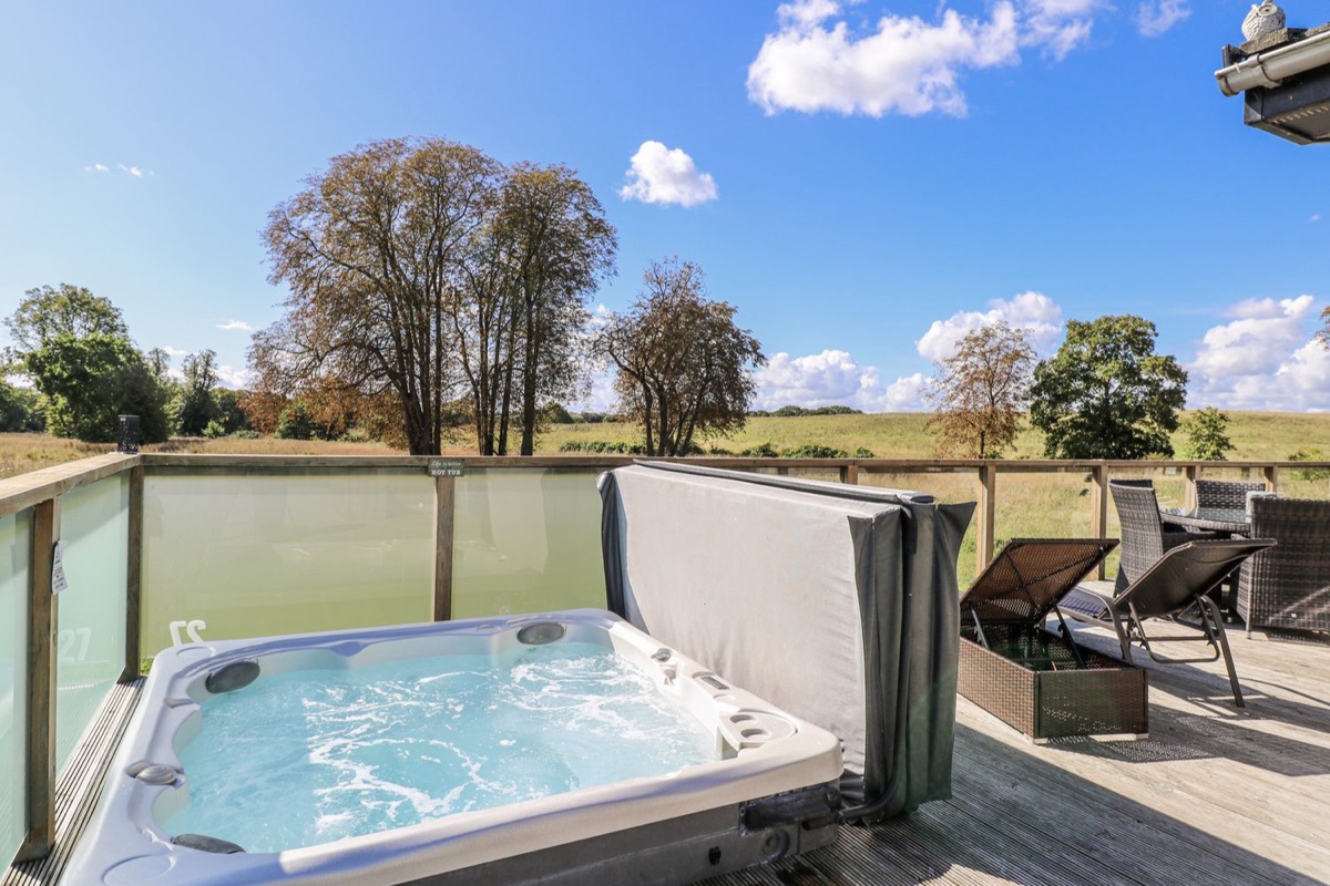 Hot tub on the deck with open field views at Angel Lodge