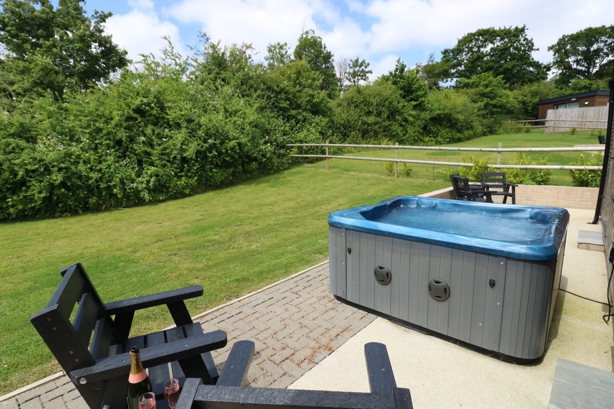 Barolo hot tub and patio chairs beside the lawn