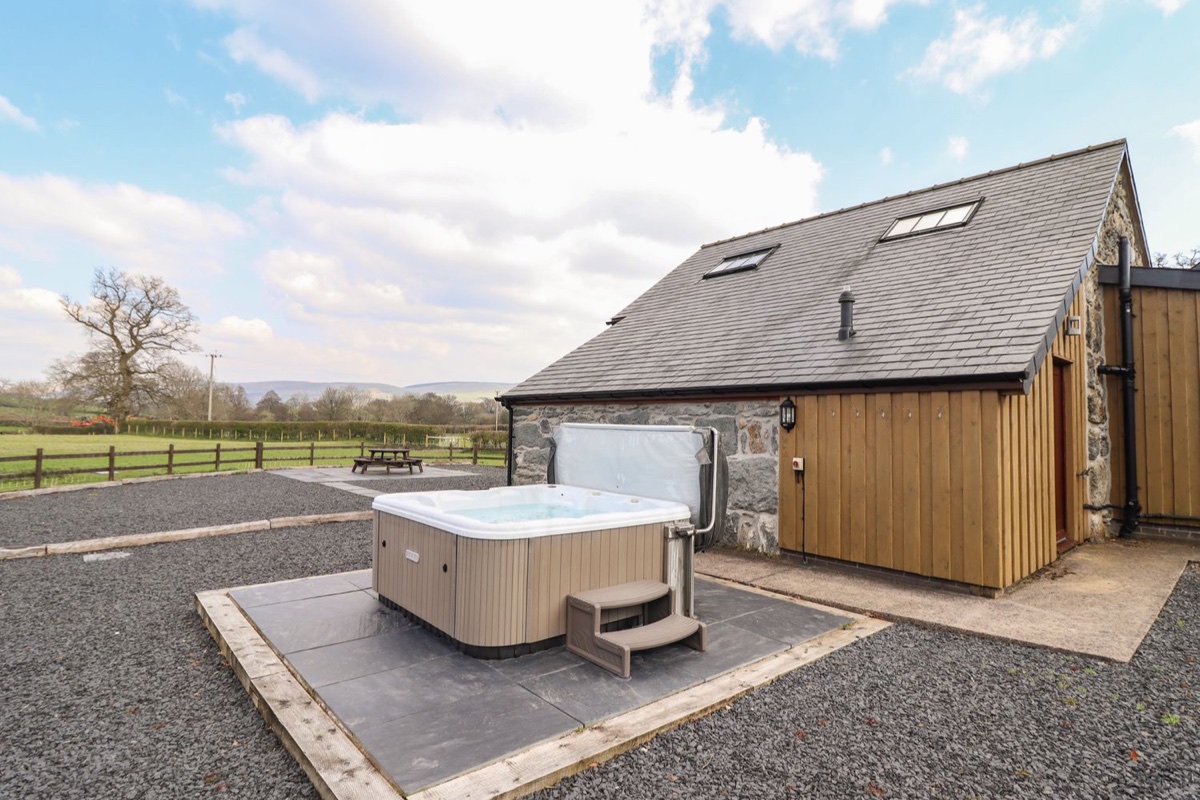 Beudy Bach Barn exterior with hot tub in the foreground