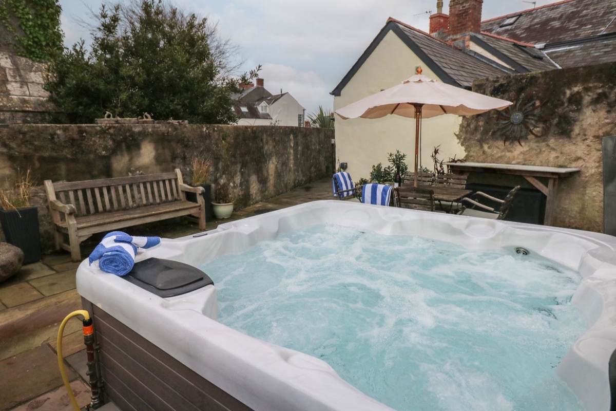 Hot tub in the stone-walled courtyard at Blacksmiths Cottage
