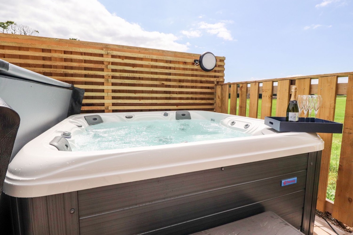 Box Tree Escapes hot tub with open fields beyond the fence