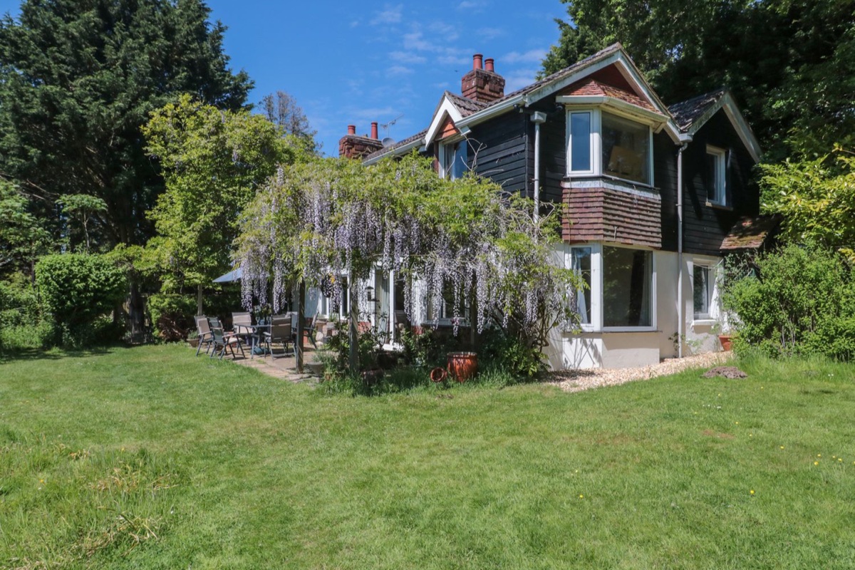 Brook Farm exterior with lawn, wisteria and garden seating