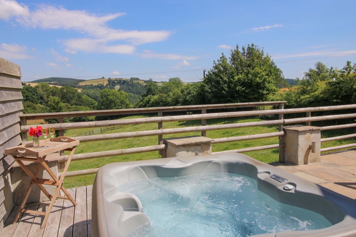 Brynlikky Cottage hot tub on the terrace looking over green hills