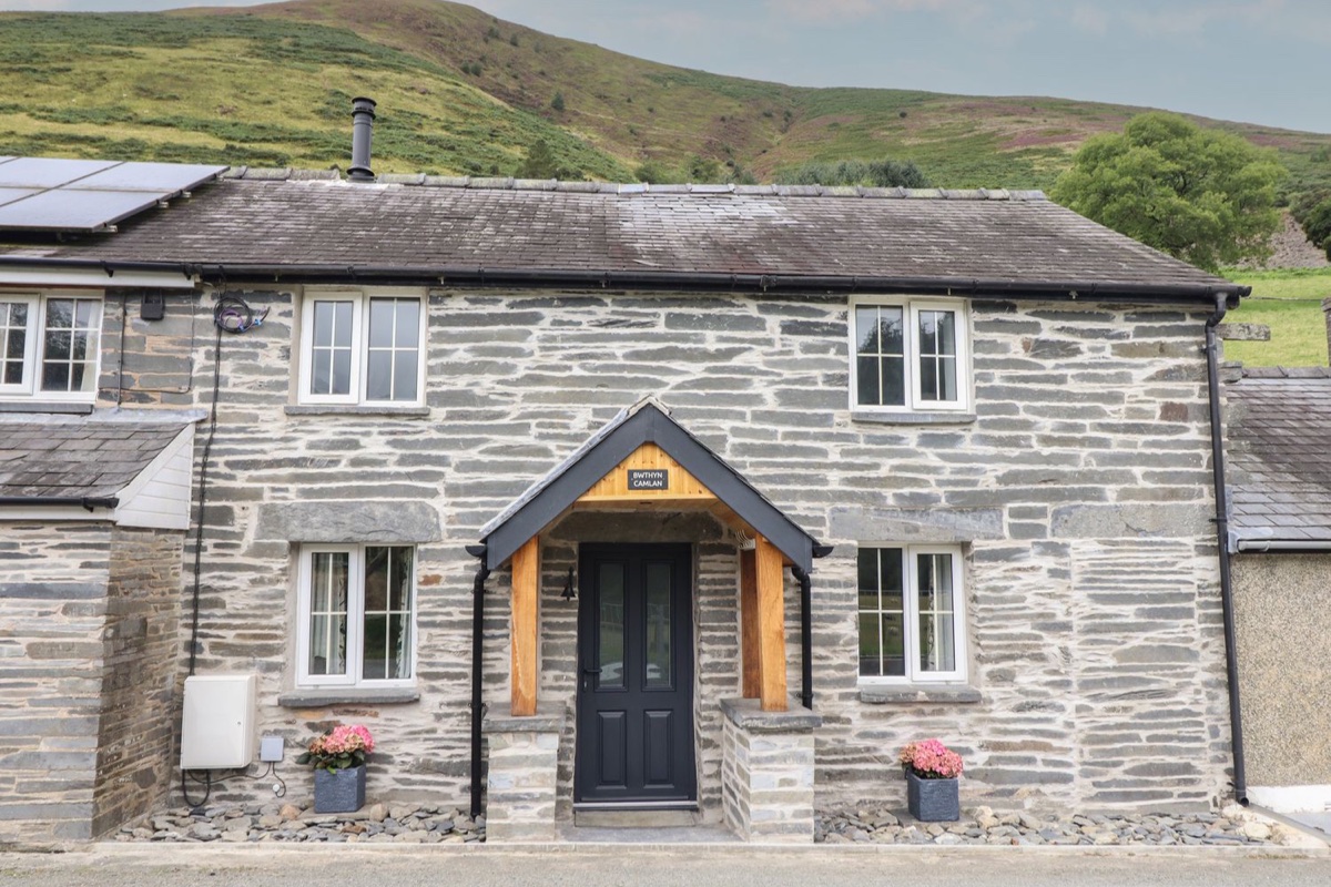 Bwthyn Camlan stone cottage exterior with green hillside