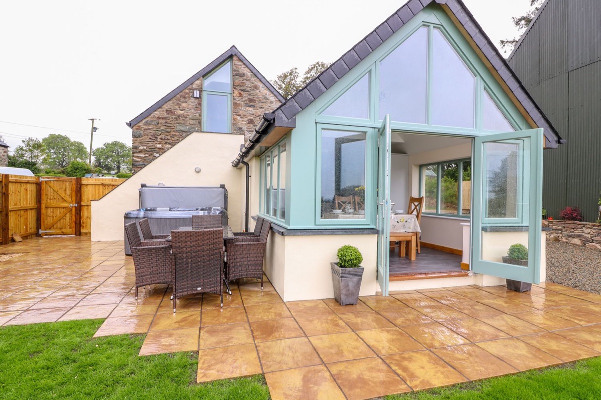 Barn conversion with a glazed apex garden room and patio at Bwthyn Eisteddfa Fach