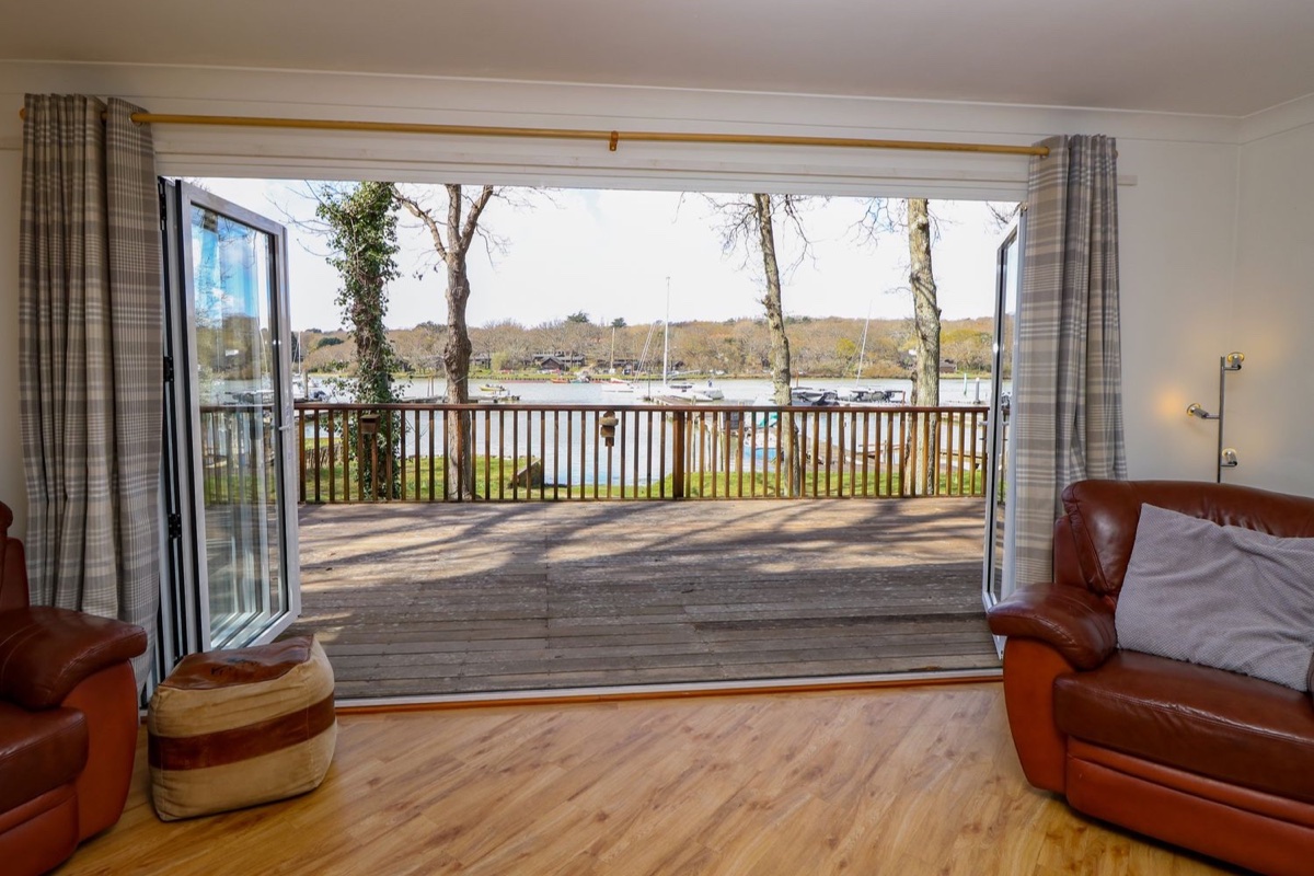 Byewater lounge opening to a creekside deck and moored boats
