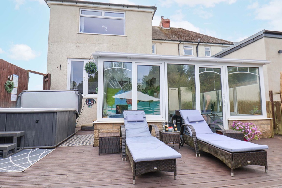 Castle View rear patio with hot tub, loungers and house exterior