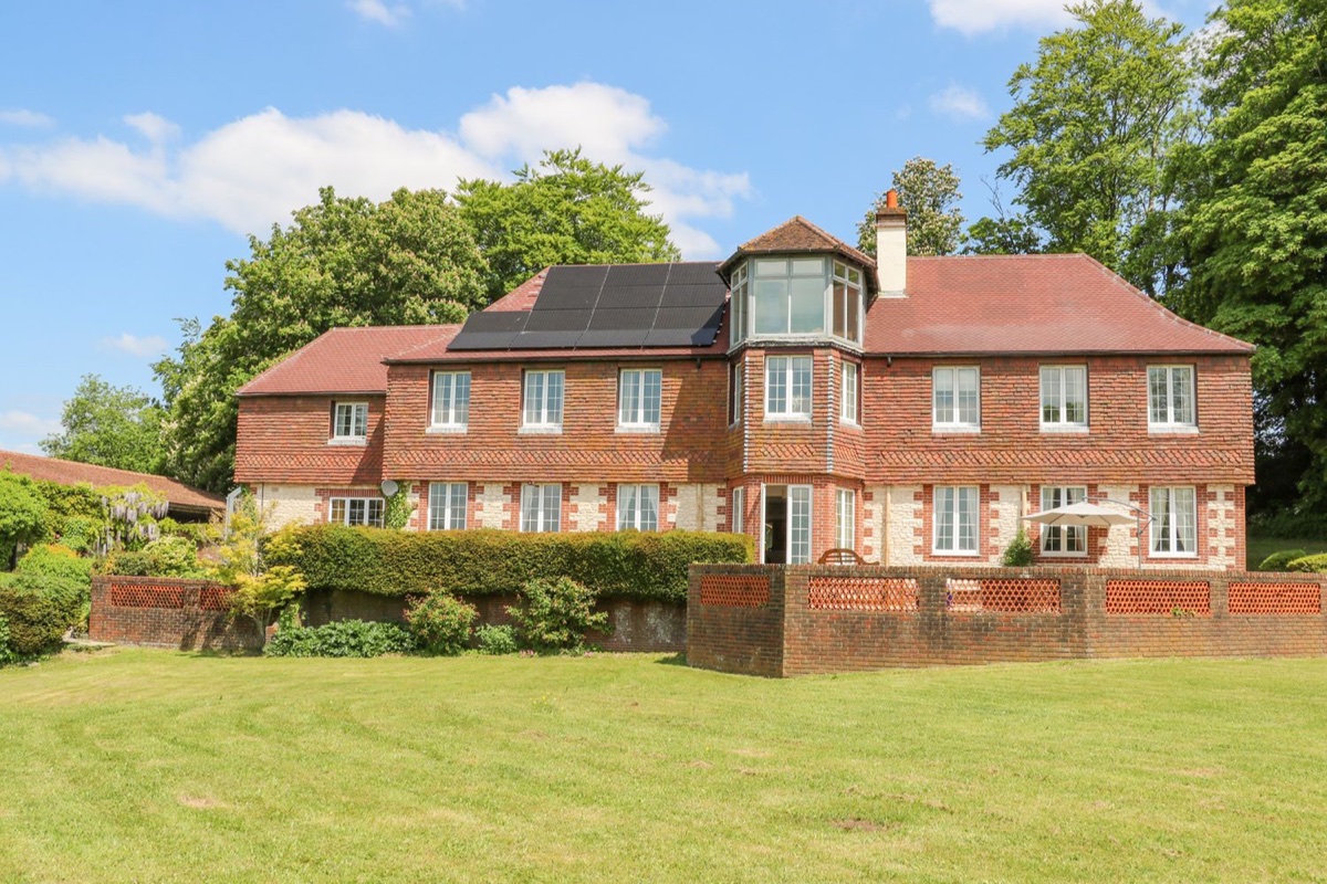 Coombe Place House exterior with lawn and red-tiled roof