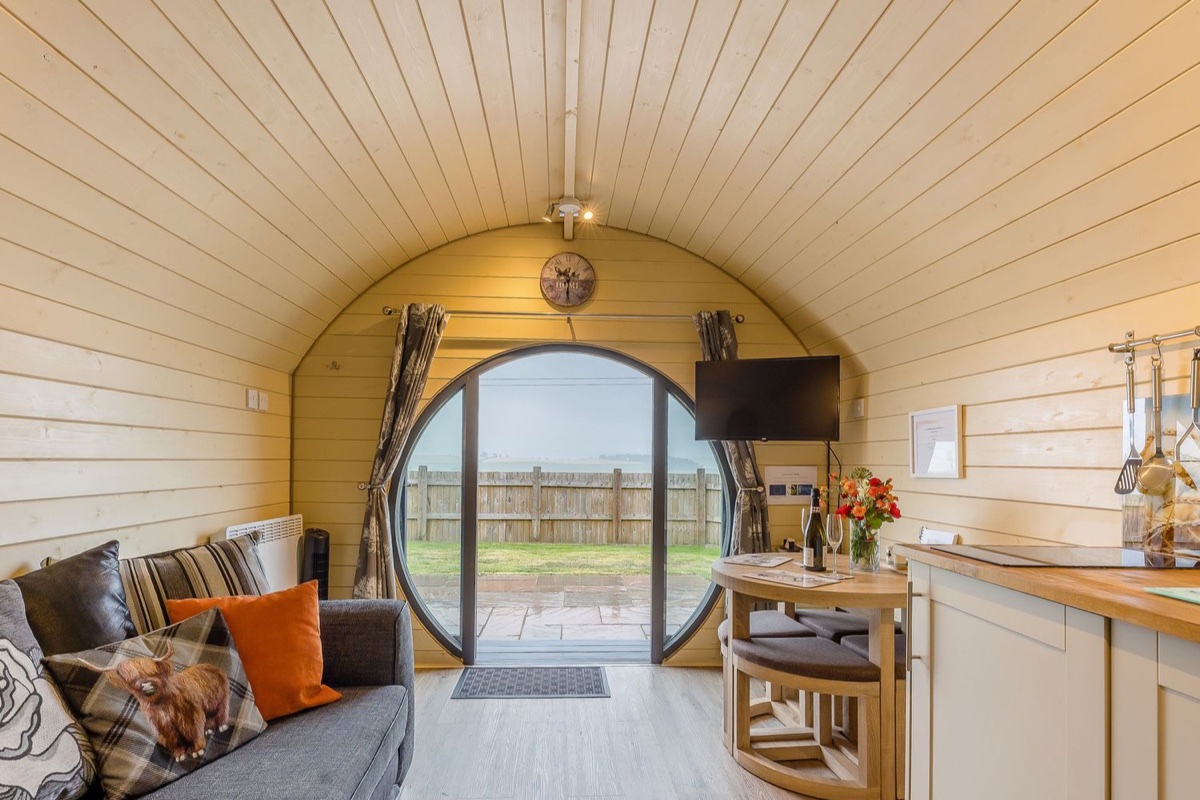 Round-door living space inside Corndon Pod with countryside views