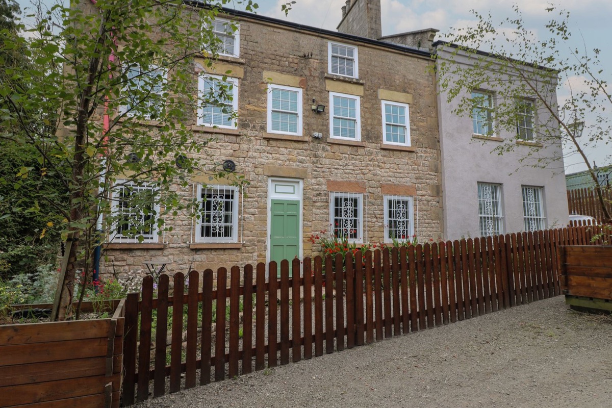 Cotton Mill Cottage stone exterior behind a low wooden fence