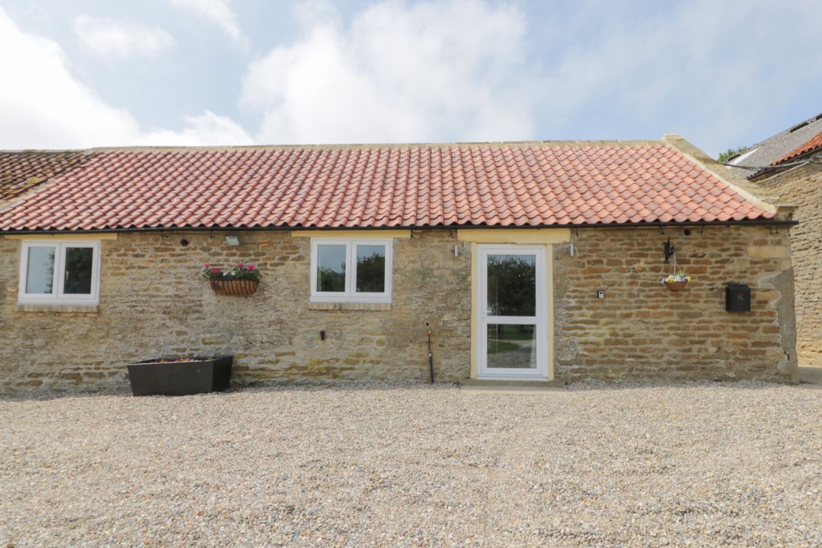 Crabtree Cottage stone exterior with red tiled roof and gravel courtyard
