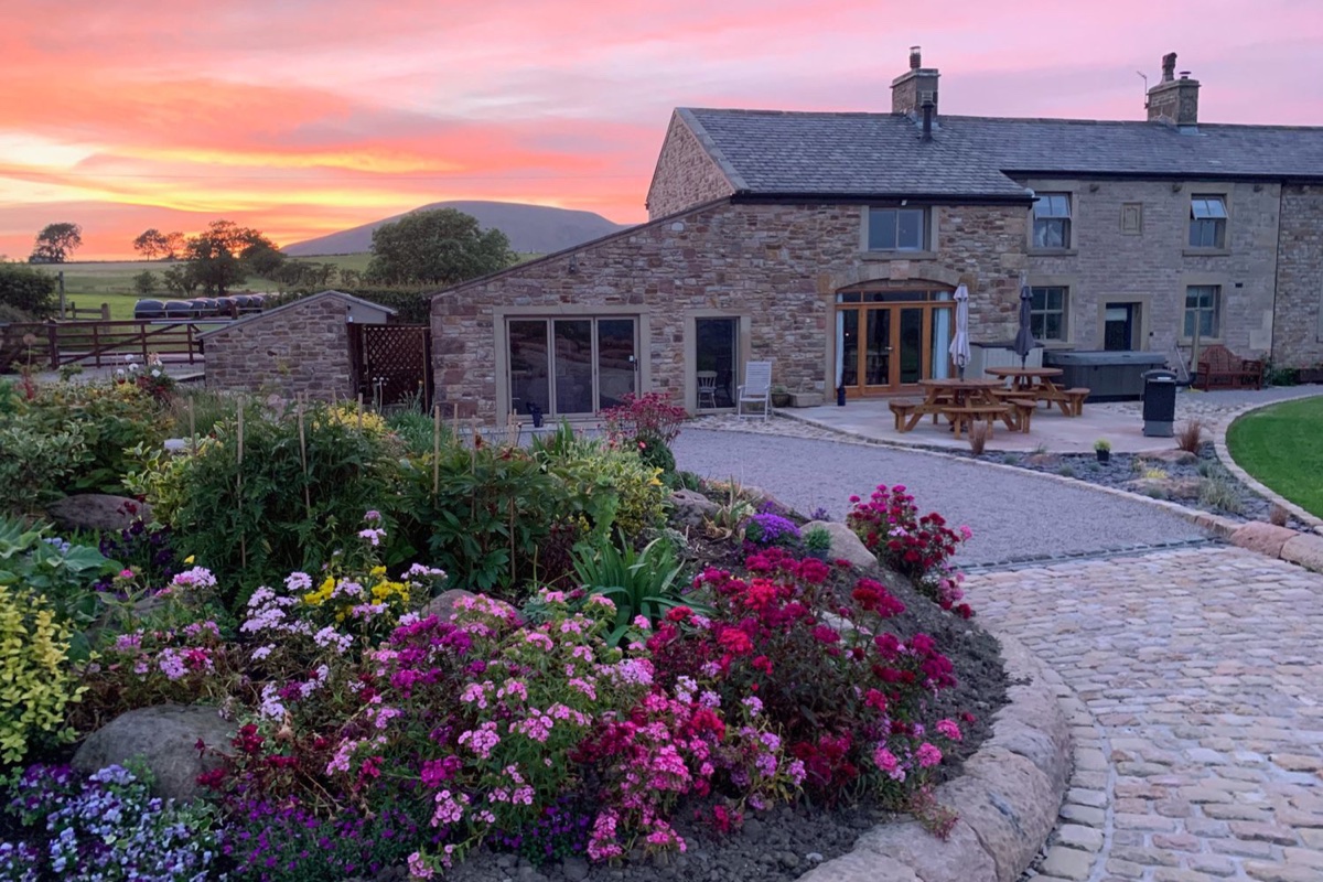 Cuthbert Hill Farm stone house and flower garden at sunset
