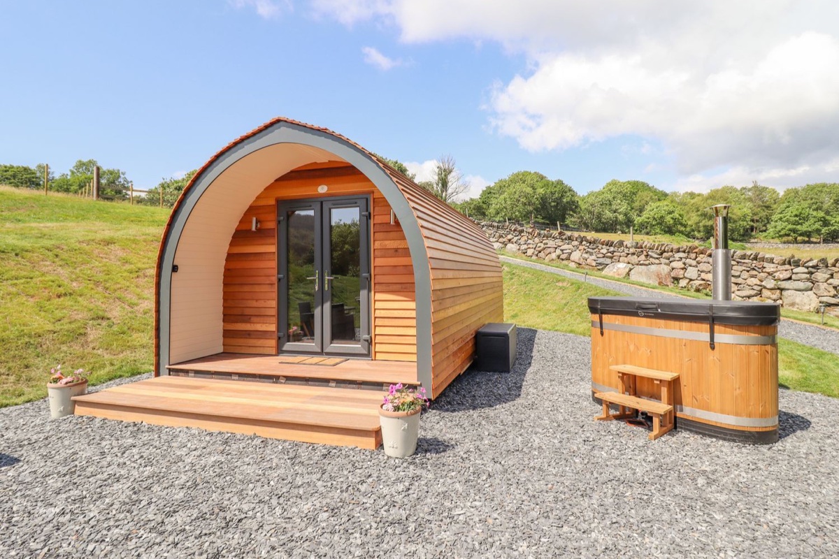 Eirlys pod exterior with private wooden hot tub beside it