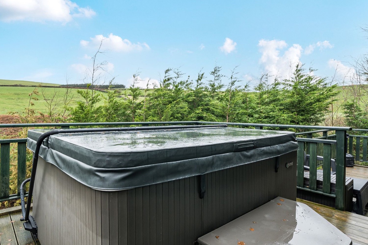 Hot tub on the raised deck overlooking green Cumbrian countryside at Elm Lodge