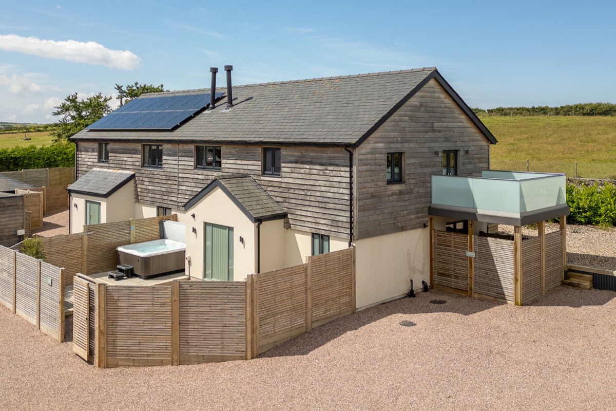 Farmyard House exterior with fenced patio and hot tub