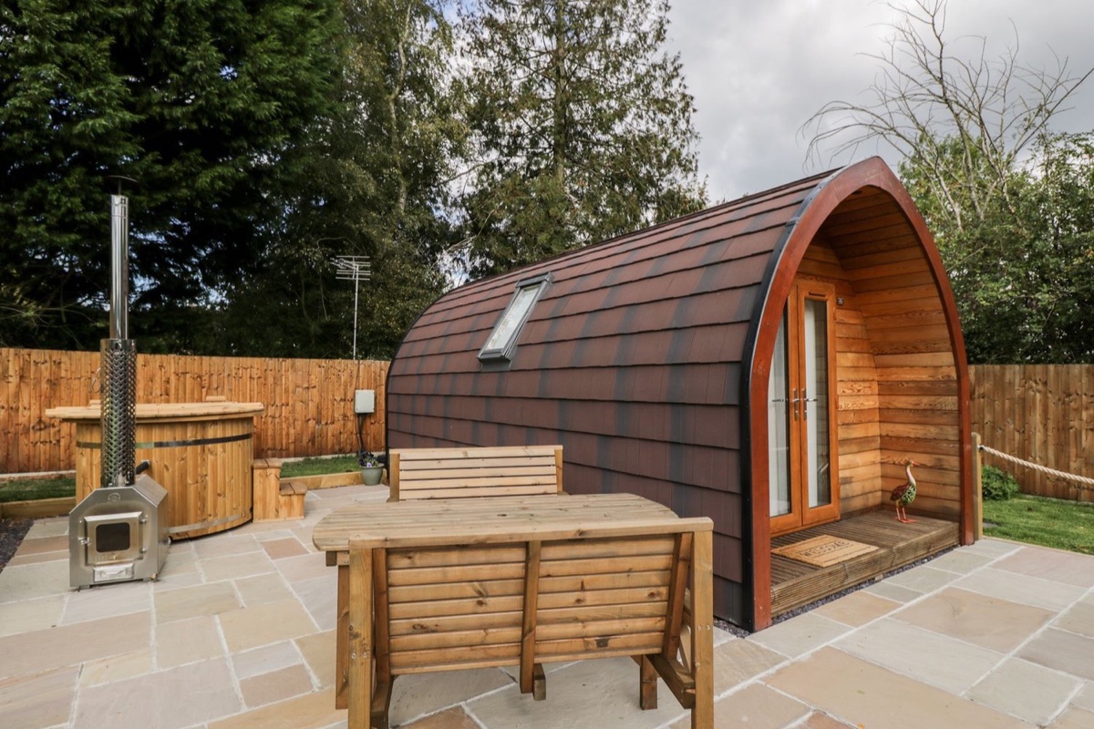 Halmore Pod exterior with wood-fired hot tub in a private garden