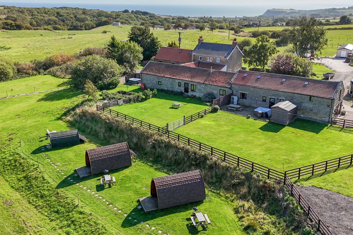 Hayloft barn and gardens in open countryside with the coast beyond
