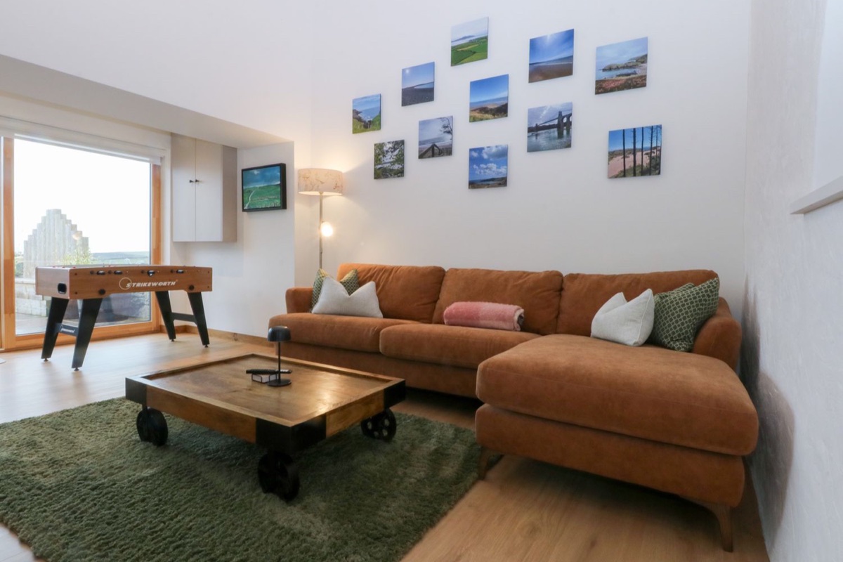 Hen Penmynydd lounge with games table and stone walls