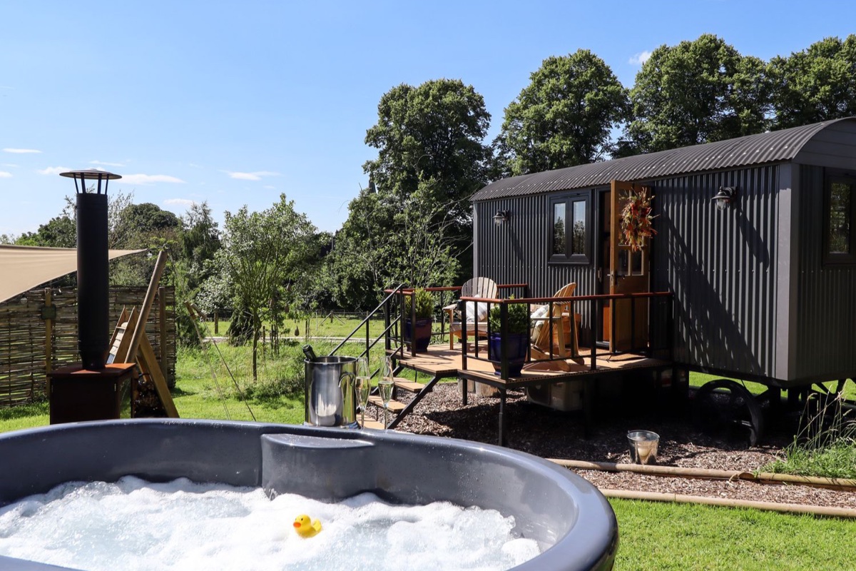 Herdwick Luxury Glamping hot tub in front of the hut and garden