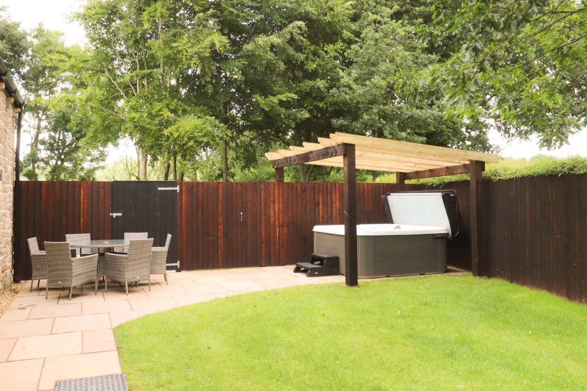Heron View garden with lawn, outdoor dining and hot tub