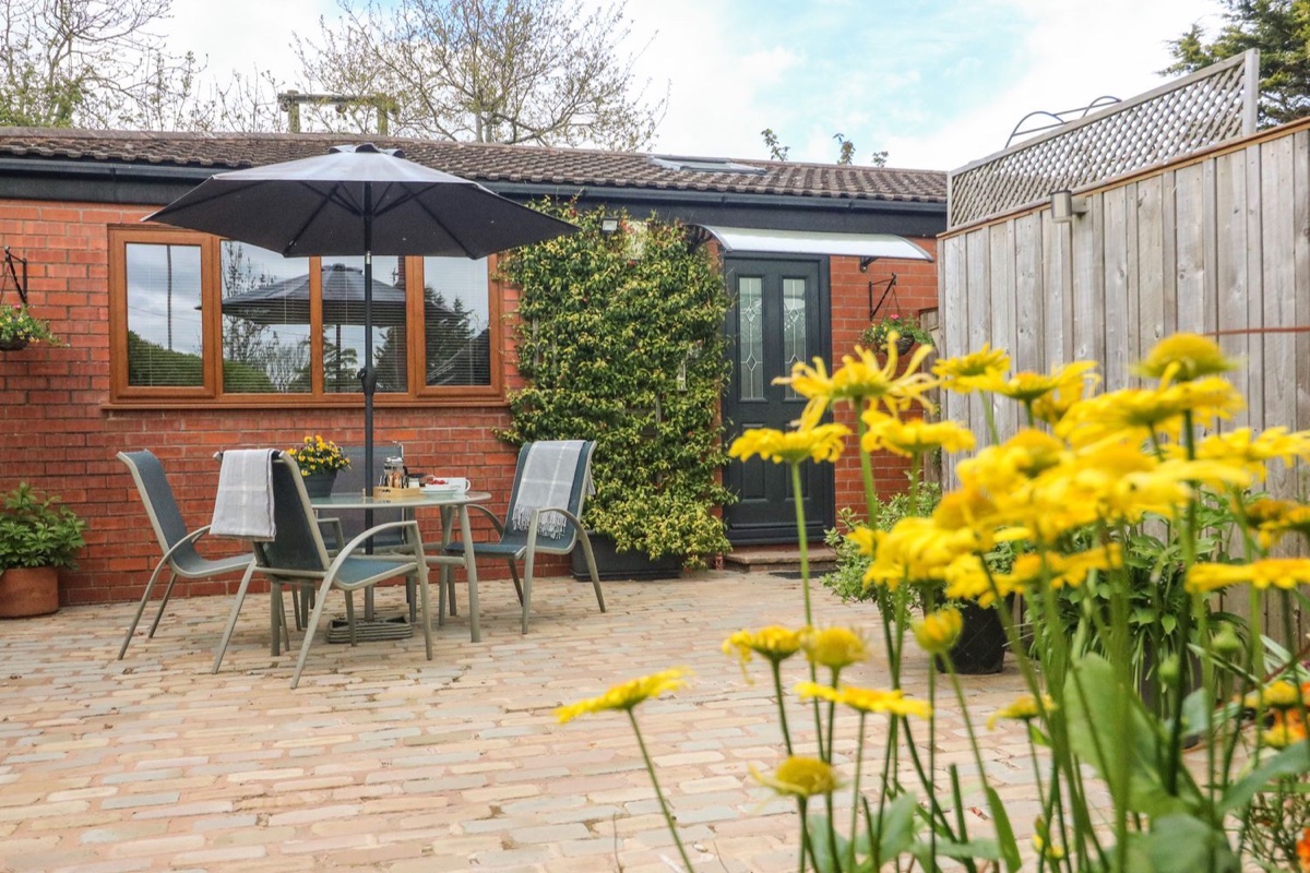 Kilmory Lodge patio with outdoor dining beside the brick house