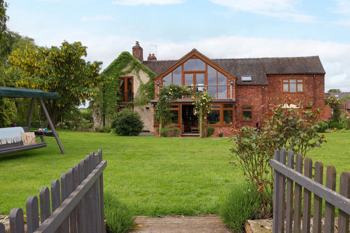 Lake View Cottage exterior seen across the garden gate and lawn