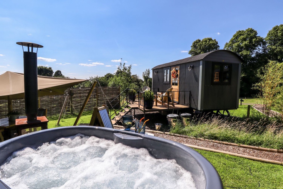 Southdown hut with bubbling hot tub in the garden foreground