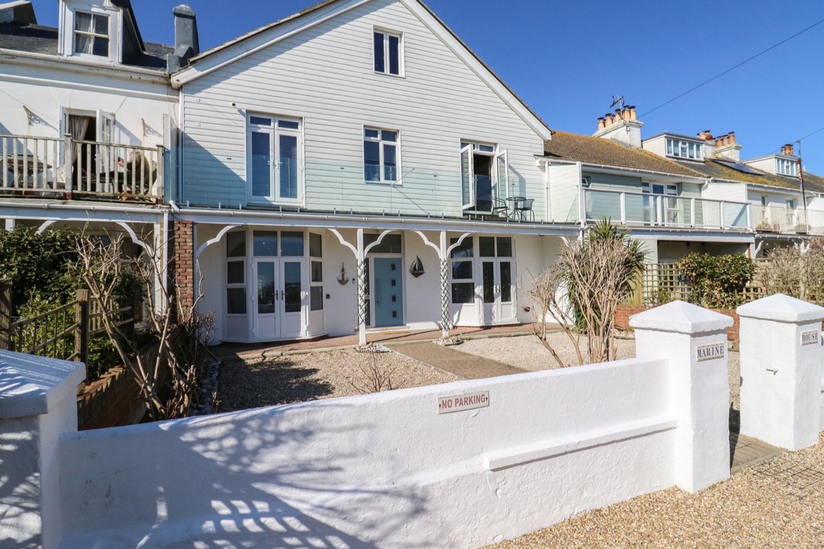 Marine House, a pale blue weatherboarded seaside house with a balcony at Pevensey Bay