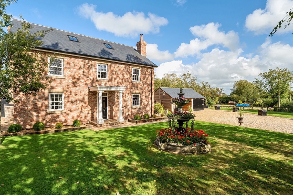 Moor End Manor brick exterior with lawn and garden fountain