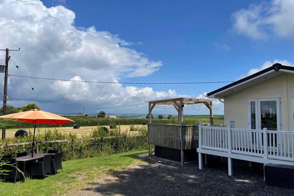 Mountain View Lodge patio and hot tub area with countryside beyond