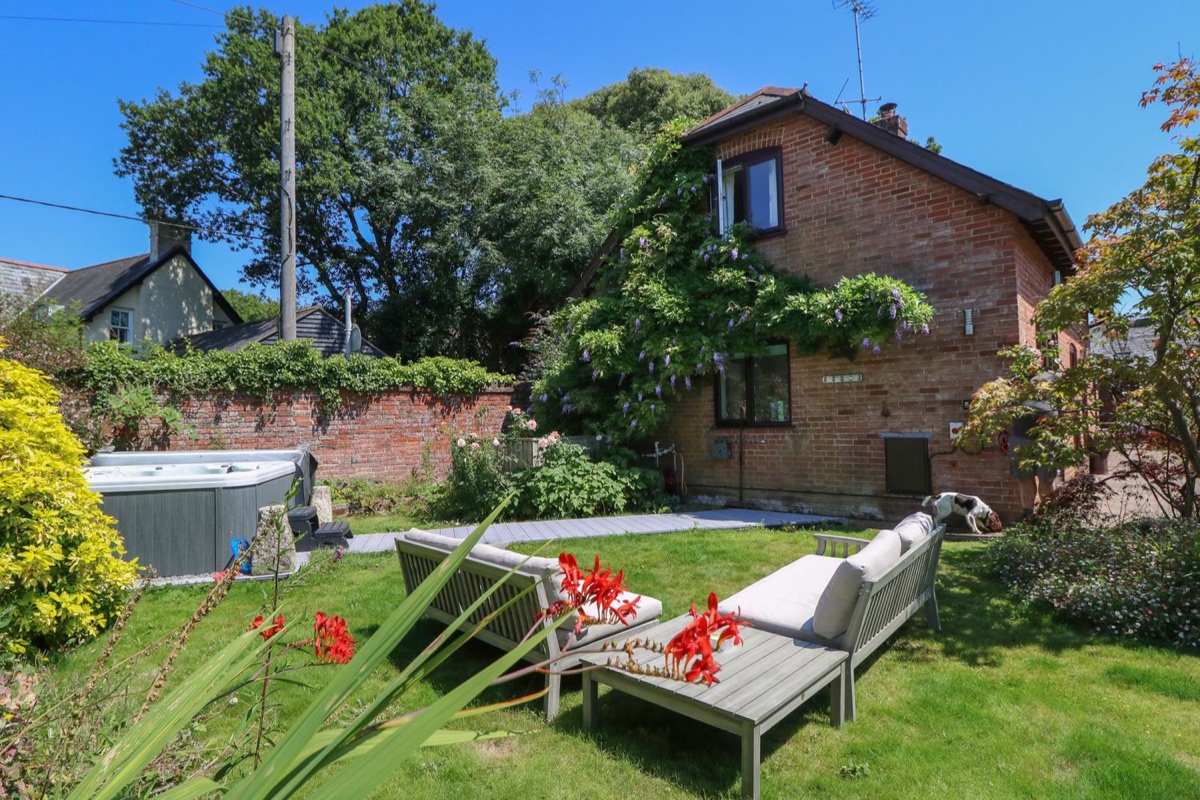 Northern Byre garden seating and hot tub beside the brick house
