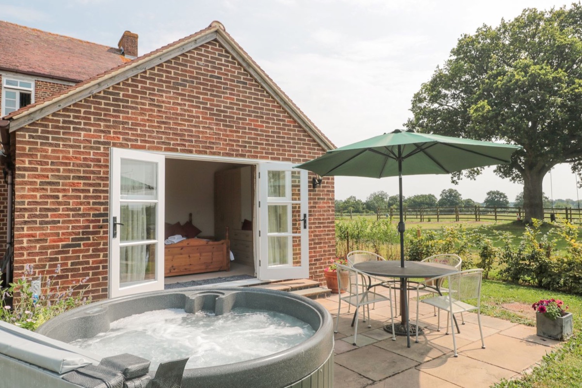 Hot tub and garden beside Oak Tree Cottage with countryside beyond
