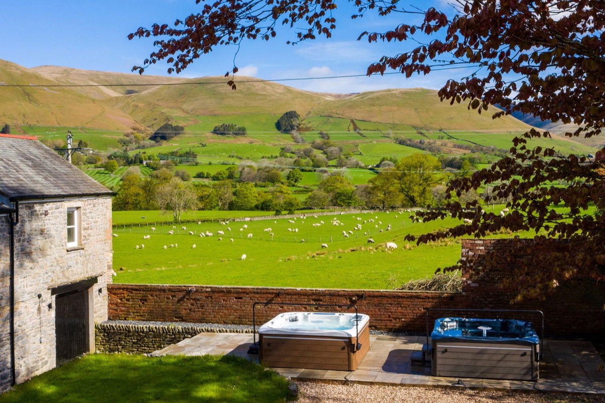 Hot tubs in the garden at Oakdene Country House with sheep and Howgill Fells