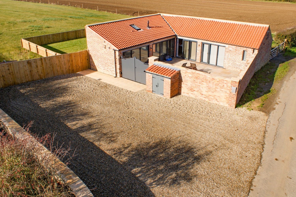 Owl View brick barn exterior with fenced lawn and open fields beyond
