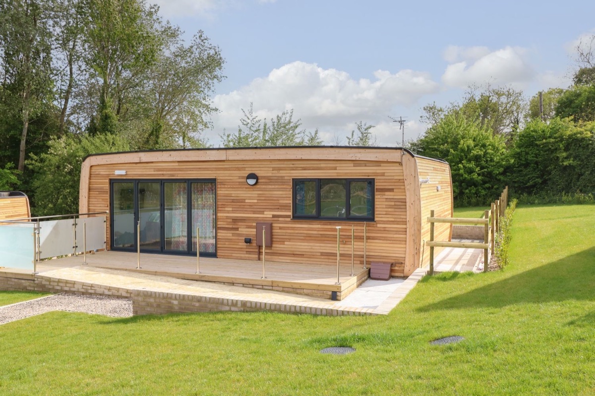 Pinot timber lodge exterior with lawn and trees in Seaview