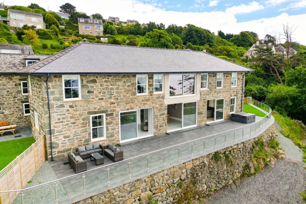 Plas Amherst stone exterior with terrace seating and hot tub