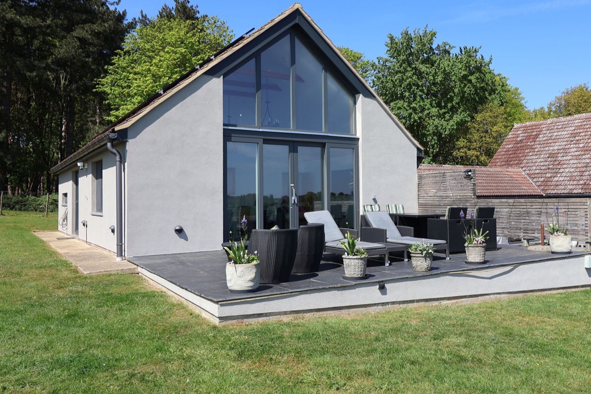Glass-fronted Polly's Annexe with terrace seating and lawn