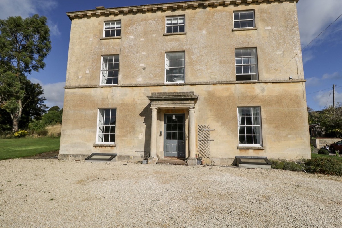 Rockstowes House front exterior with tall sash windows and gravel drive