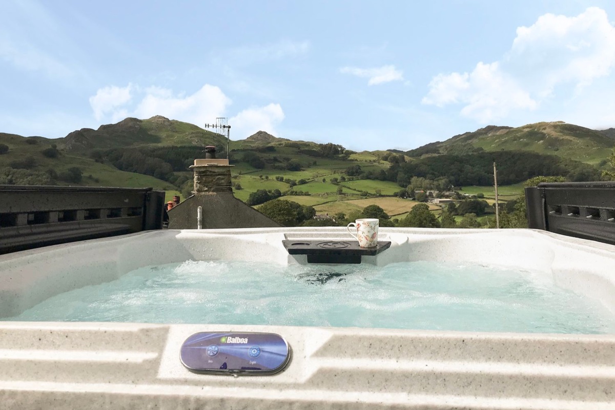 Bubbling hot tub overlooking fell panorama at Rose Cottage near Broughton-in-Furness