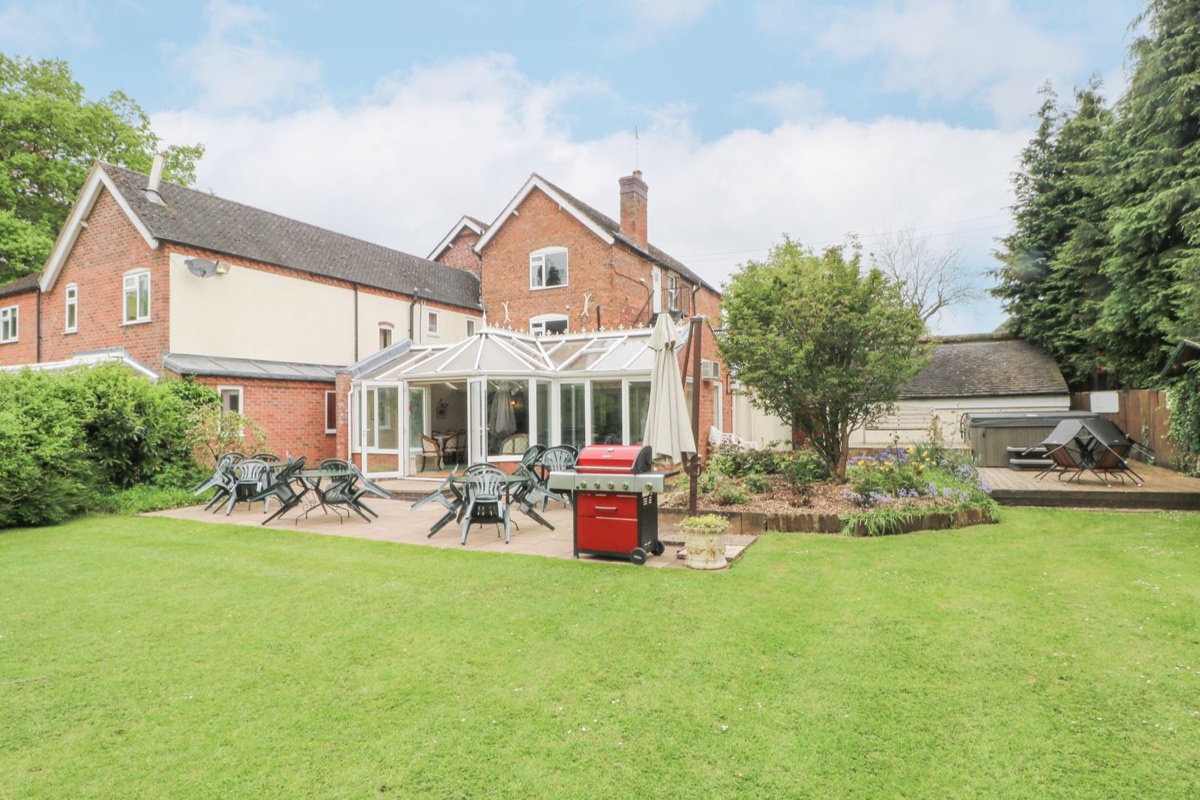 Rosehill Manor garden-side exterior with patio seating and hot tub deck