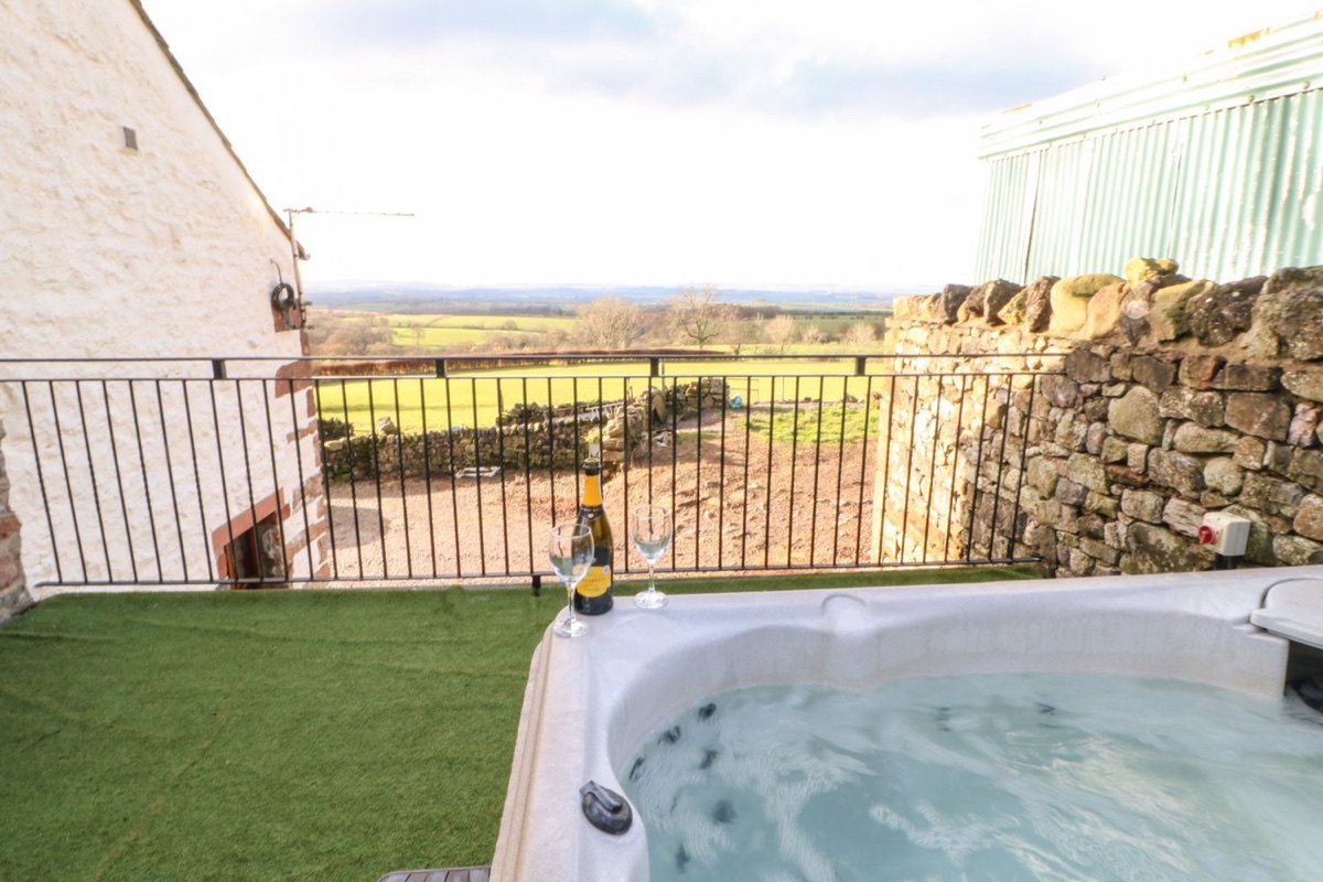 Hot tub with champagne flutes and rolling Eden Valley countryside views beyond