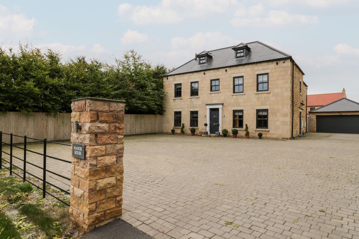 Seamer Manor House stone frontage across a gated driveway