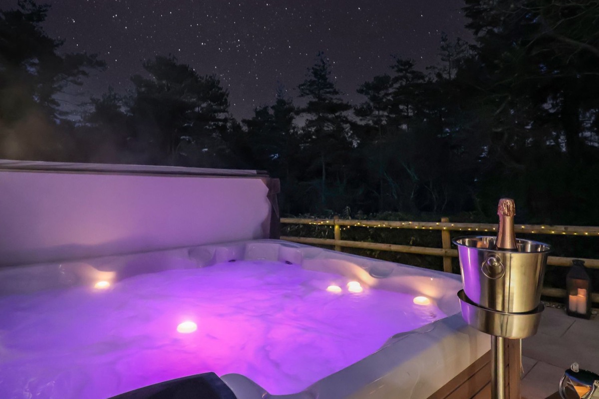 Hot tub at Stag Cottage, Lytchett Matravers, glowing purple under a starry sky with champagne on ice