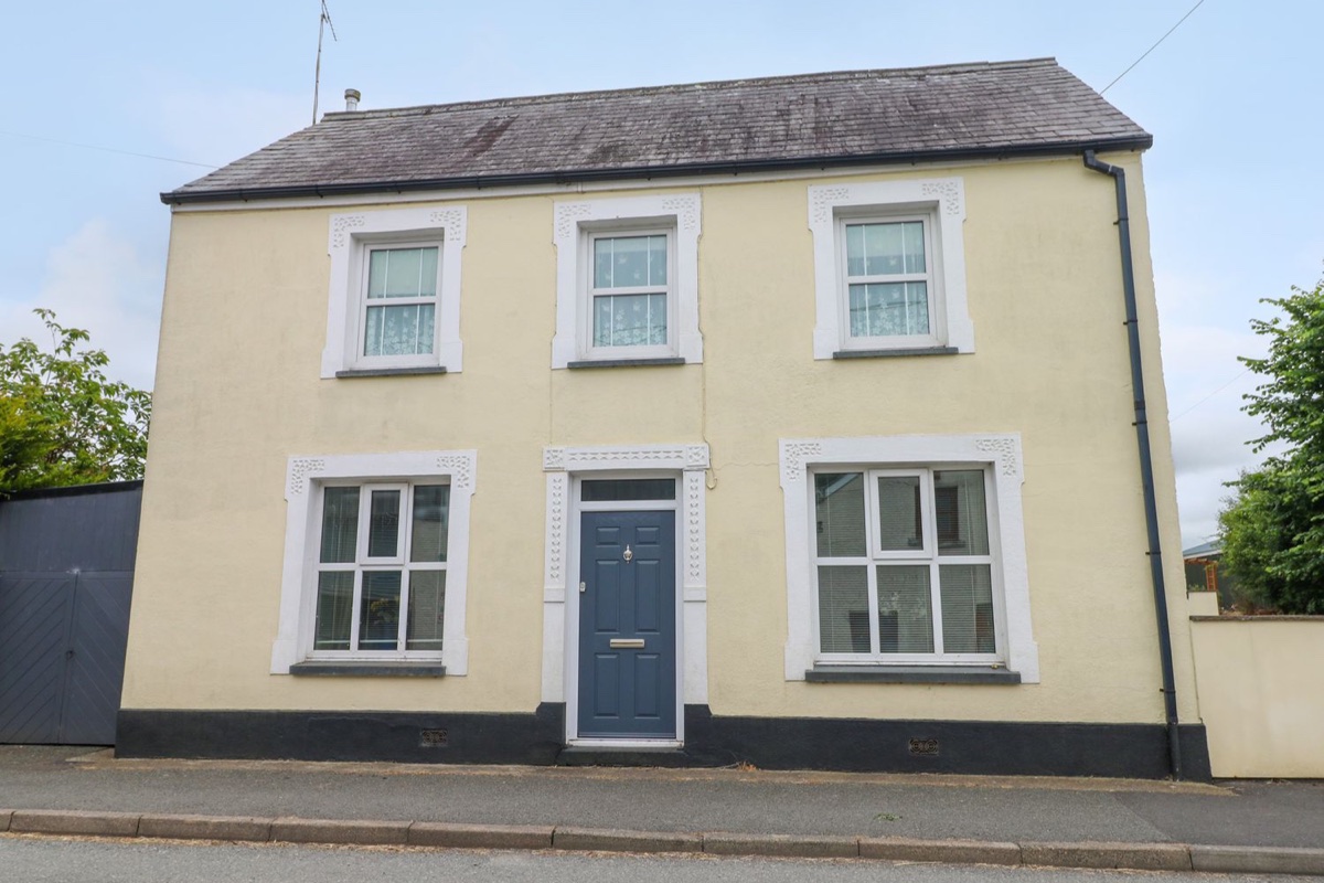 Cream double-fronted village house with blue door at Station Hall in Cilgerran