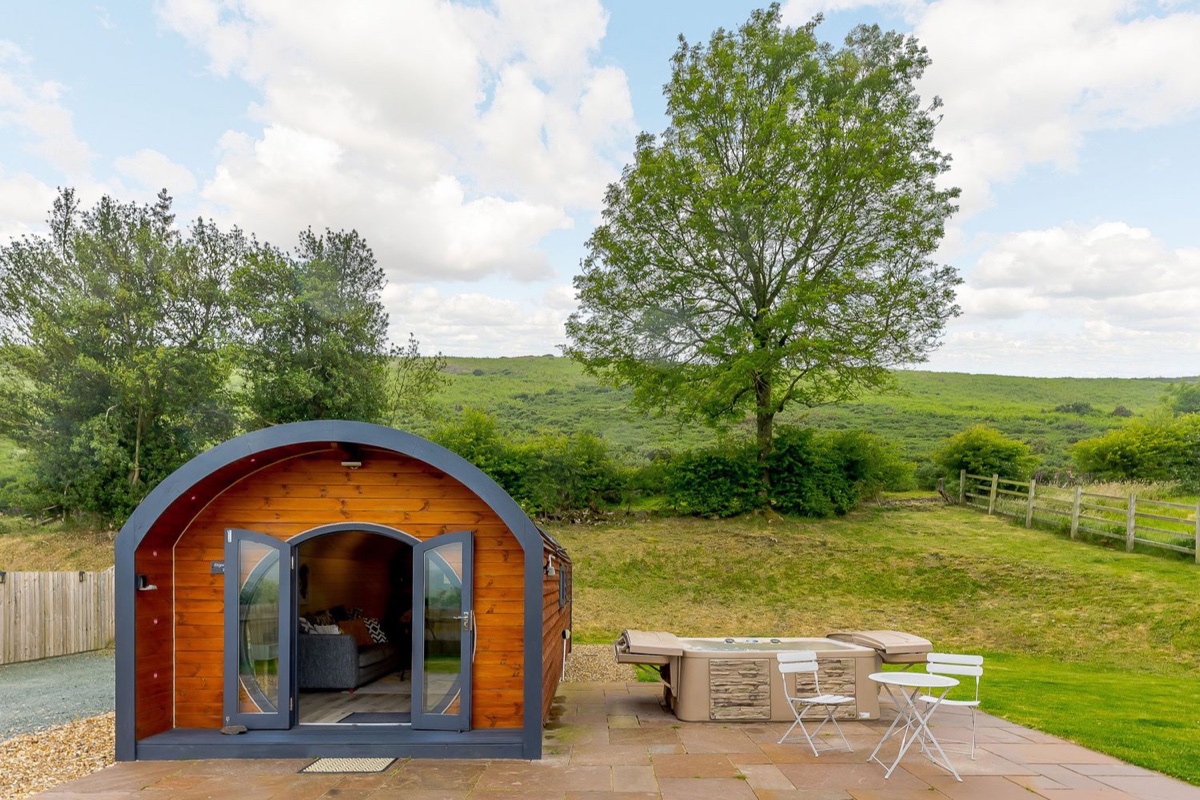 Stiperstones Pod exterior with patio and green Shropshire hillside behind
