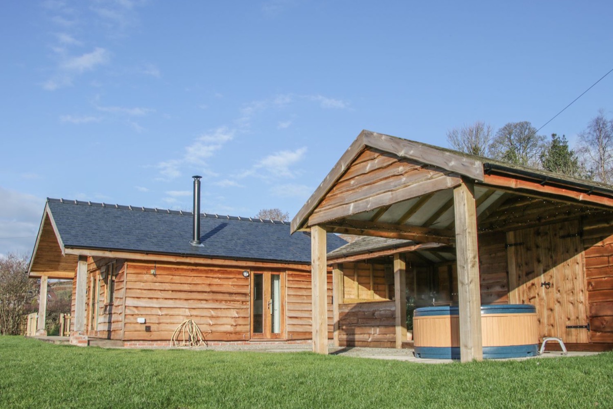 Stoney-Brook Lodge exterior with covered hot tub beside the lawn